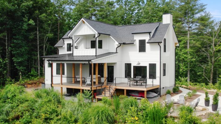 This home is called "Laurel Park Craftsman." It is a custom built two-story home with aa white and black exterior with some wooden accents.