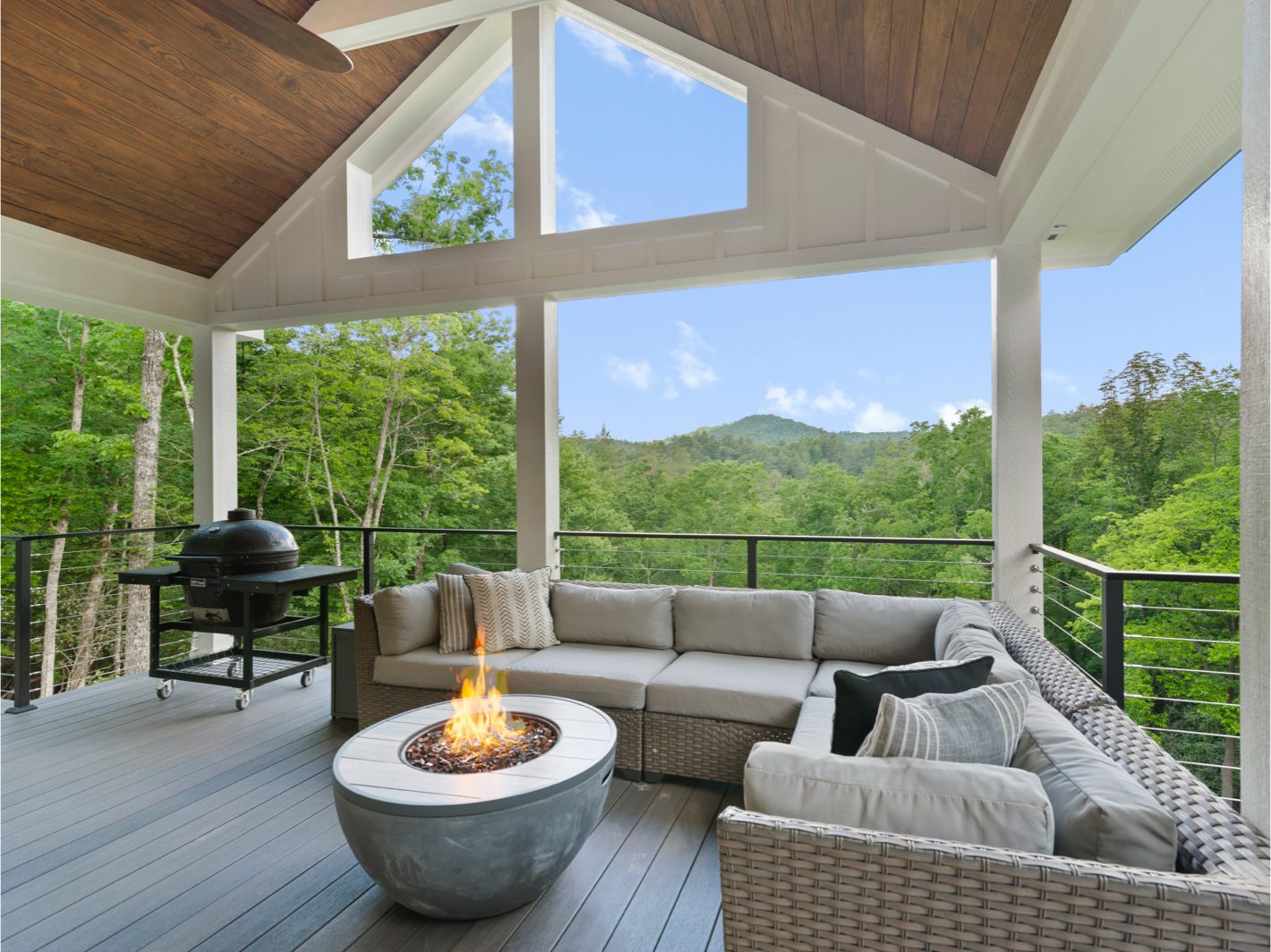 The top deck features an outdoor sectional sofa with an enclosed fire pit and a grill.